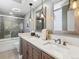 Modern bathroom featuring a double sink vanity, decorative mirrors, and a glass-enclosed shower and bathtub at 1111 Race St # 3A, Denver, CO 80206