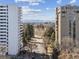An exterior view of the property showing the tree lined street, buildings, and Denver skyline at 1111 Race St # 3A, Denver, CO 80206