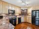 Kitchen features wood floors, granite countertops, tile backsplash, black appliances, and plenty of cabinet space at 1111 Race St # 3A, Denver, CO 80206