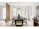 Dining room with a long black table, seating for six, a modern chandelier and three large windows at 4481 Raleigh St, Denver, CO 80211