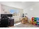 Inviting bedroom with a window view, a desk for focused work, and colorful storage for a vibrant space at 18366 E 102Nd Pl, Commerce City, CO 80022