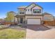 Charming two-story home with a well-manicured lawn and a brick driveway during daylight at 18366 E 102Nd Pl, Commerce City, CO 80022