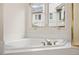 Large soaking tub with jets and a window overlooking the yard at 14032 E Chenango Dr, Aurora, CO 80015
