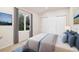 Bright bedroom featuring a large window, closet with sliding doors, and neutral color scheme at 14032 E Chenango Dr, Aurora, CO 80015