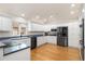 Spacious kitchen featuring modern stainless steel appliances and custom white cabinetry at 14032 E Chenango Dr, Aurora, CO 80015