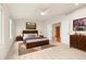 Spacious main bedroom with hardwood accents, ceiling fan, ensuite entrance, and dresser on the right at 14032 E Chenango Dr, Aurora, CO 80015