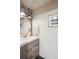 Stylish powder room featuring a modern vanity, round mirror and decorative black and white patterned wallpaper at 16046 E Ithaca Pl # C, Aurora, CO 80013