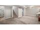Spacious basement with carpet, a staircase, an artistic mural and a doorway leading to another room at 2465 W Mosier Pl, Denver, CO 80223