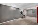Carpeted basement with painted walls, a small window, and a minimalist bench, providing a simple, clean aesthetic at 2465 W Mosier Pl, Denver, CO 80223