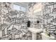 Unique bathroom showcasing pedestal sink and whimsical cityscape-themed wallpaper at 2465 W Mosier Pl, Denver, CO 80223