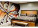 Bedroom with a queen bed, unique wall art, and a wooden bench, creating a comfortable and artistic space at 2465 W Mosier Pl, Denver, CO 80223