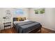 Cozy bedroom with hardwood floors, two windows, and modern decor, creating a comfortable and inviting space at 2465 W Mosier Pl, Denver, CO 80223