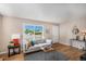 Bright living room featuring hardwood floors, a comfortable sofa, and a view of the neighborhood at 2465 W Mosier Pl, Denver, CO 80223