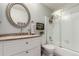 Bright bathroom with a vanity, round mirror, and a shower-tub combination with sliding glass doors at 3082 W 107Th Pl # H, Westminster, CO 80031