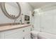Bright bathroom with a vanity, round mirror, and a shower-tub combination with sliding glass doors at 3082 W 107Th Pl # H, Westminster, CO 80031