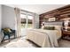 Well-lit bedroom with wooden accent wall, plush bed, and bright window overlooking the lawn at 3082 W 107Th Pl # H, Westminster, CO 80031