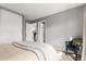 Neutral bedroom showing two entryways, closet, wicker chair and sunlit windows at 3082 W 107Th Pl # H, Westminster, CO 80031