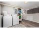 Efficient laundry area featuring a washer, dryer, storage shelves, and modern flooring near the finished basement stairs at 3082 W 107Th Pl # H, Westminster, CO 80031