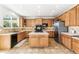 This kitchen has an island with cooktop, lots of counter space and cabinetry, a black oven, and tile floors at 3532 Springbriar Dr, Castle Rock, CO 80109