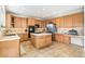Large kitchen with wooden cabinets, stainless steel refrigerator and appliances, and a tile cooktop island at 3532 Springbriar Dr, Castle Rock, CO 80109