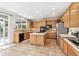 Spacious kitchen featuring wooden cabinets, an island cooktop, stainless steel appliances, and tile flooring at 3532 Springbriar Dr, Castle Rock, CO 80109