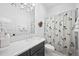 Bathroom with stylish floral shower curtain and marble countertop sink at 652 S Race St, Denver, CO 80209