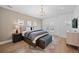 Bright bedroom with a king bed, modern chandelier, sitting bench and ample natural light from multiple windows at 652 S Race St, Denver, CO 80209