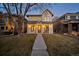 Inviting two-story home featuring a covered porch, white siding, metal roof and manicured lawn at 652 S Race St, Denver, CO 80209