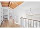 Upstairs hallway featuring wood floors, modern lighting, white walls, and railing, plus a glimpse of a nearby bedroom at 652 S Race St, Denver, CO 80209