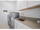 Modern laundry room featuring stainless steel washer and dryer at 652 S Race St, Denver, CO 80209