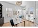 Bright home office with white walls, modern desk, statement lighting, and ample natural light from large windows at 652 S Race St, Denver, CO 80209