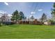 Spacious backyard featuring a covered patio, mature trees, and a well-maintained lawn at 500 Fulton St, Aurora, CO 80010