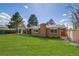 Spacious backyard featuring a well-manicured lawn, covered patio, and mature trees at 500 Fulton St, Aurora, CO 80010
