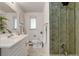 Bathroom with modern vanity, toilet, and a shower with stylish marble-like tile at 500 Fulton St, Aurora, CO 80010
