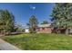 Charming red brick single-story home with a manicured lawn, mature trees, and an attached garage at 500 Fulton St, Aurora, CO 80010