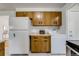 Practical kitchen with white appliances, classic cabinets, counterspace, and laundry area at 500 Fulton St, Aurora, CO 80010
