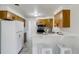 Well-lit kitchen featuring wooden cabinets, and breakfast bar, with view of dining area at 500 Fulton St, Aurora, CO 80010