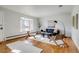 Sunlit living room with hardwood floors, a modern sofa, and stylish accent chairs at 500 Fulton St, Aurora, CO 80010