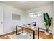 Bright home office featuring hardwood floors, stylish rug, modern desk, and a sunlit window at 500 Fulton St, Aurora, CO 80010