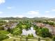 Picturesque aerial view of a community with a pond, walking paths and mountain views on a partly cloudy day at 5723 S Union Ct, Littleton, CO 80127