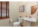 Charming half bath with a decorative mirror, toilet, and pedestal sink at 5723 S Union Ct, Littleton, CO 80127