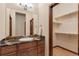 Bathroom vanity with granite countertop, wood cabinets, and an open closet at 5723 S Union Ct, Littleton, CO 80127