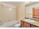 Bathroom with granite countertop, wood cabinets, and a tile shower and tub combo at 5723 S Union Ct, Littleton, CO 80127