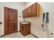 Convenient laundry room includes sink, storage cabinets, and utility door at 5723 S Union Ct, Littleton, CO 80127