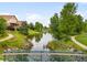 Scenic pond view with a lush green landscape, with walking paths and neighborhood at 5723 S Union Ct, Littleton, CO 80127