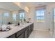 Bright bathroom featuring double sinks, ample counter space, and a glass-enclosed shower offering luxury at 14147 Bunny Hop Ln, Parker, CO 80134