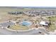 Aerial view of community amenities featuring a pool, clubhouse, playground, and ample parking in a residential area at 14582 Mission Walk Loop, Parker, CO 80134