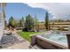 Serene backyard with a hot tub, stone fire pit, lush lawn, and scenic landscaping at 14582 Mission Walk Loop, Parker, CO 80134