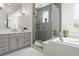 Bathroom with walk-in shower, soaking tub, gray vanity, and modern fixtures at 14582 Mission Walk Loop, Parker, CO 80134