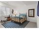 Cozy bedroom with a black metal bed, stylish mirror, desk, and striped rug at 14582 Mission Walk Loop, Parker, CO 80134